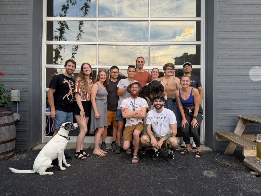 In the summer, group of climbers gather smiling to the camera.